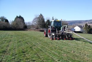 Tractor with slurry injector umbilical system on a field in Devon