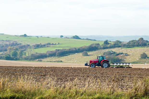 Red tractor ploughing fields